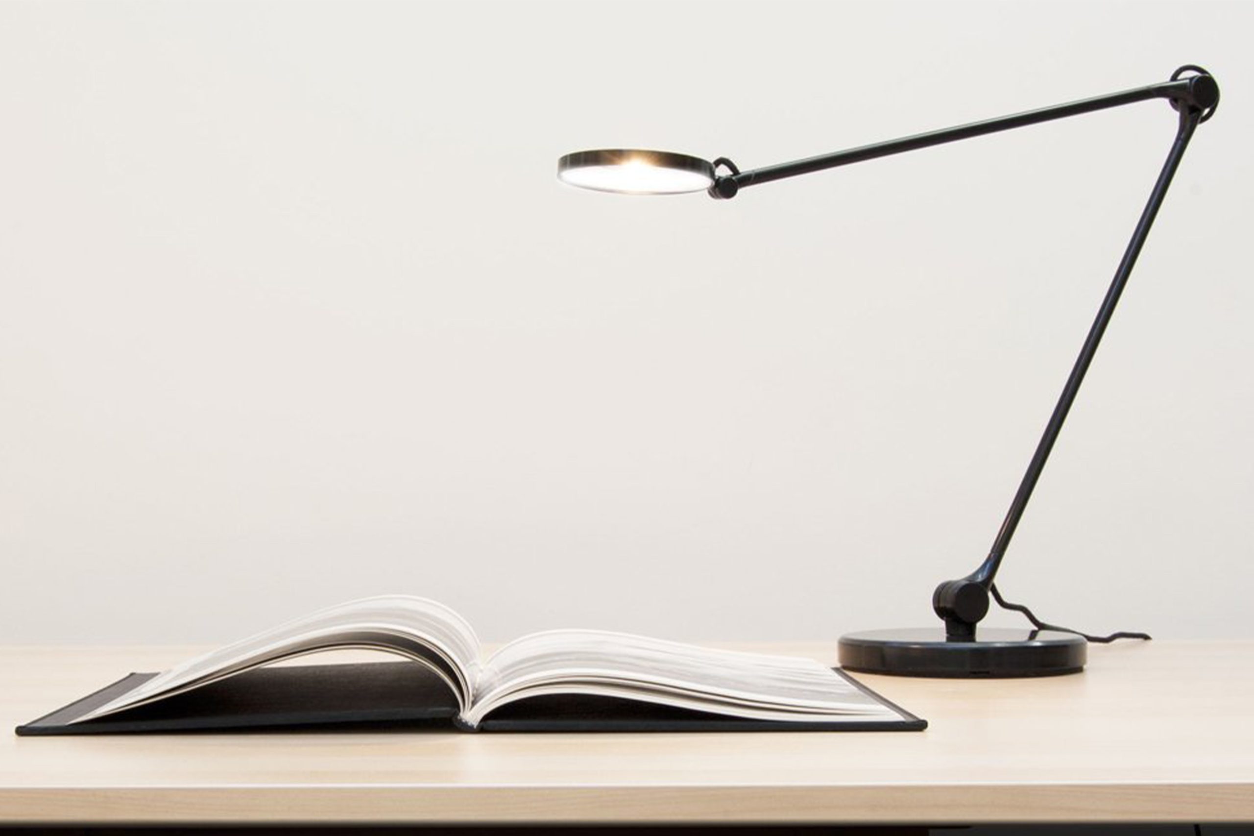 Desktop lamp shining on an open book